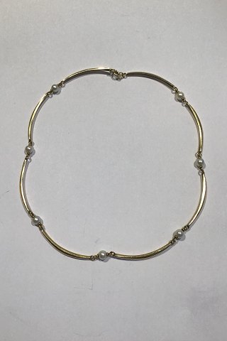 Goldnecklace 14 ct made of 8 slightly curved segments divided by pearls.