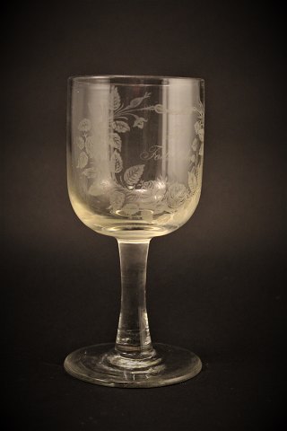 Gammelt erindrings glas fra Holmegaard glasværk med 
fine graveret blomster dekorationer og skrift "Til Fødselsdag"
H:16cm. Dia:7,5cm.