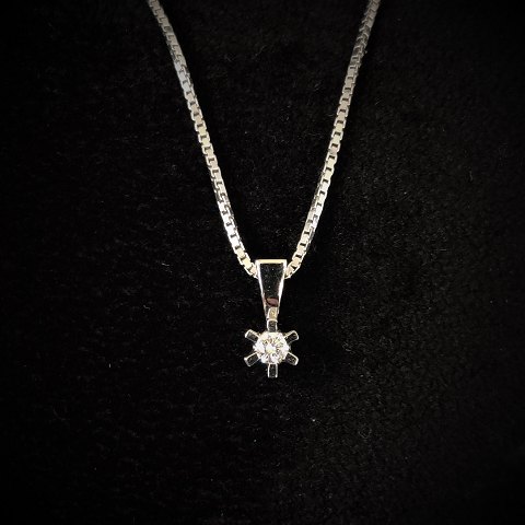 A 14k white gold necklace set with a diamond pendant