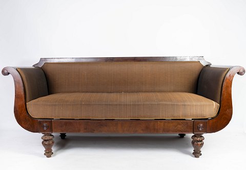 Antique sofa upholstered with brown fabric and frame of dark wood from 1860.
5000m2 showroom.