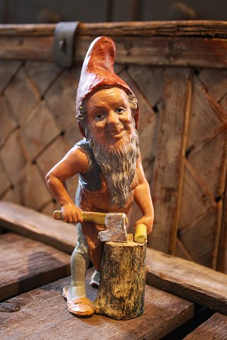 Antique painted terracotta Santa Claus chopping firewood with an axe...