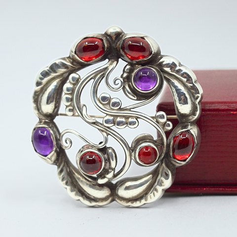 Georg Jensen; Silver brooch with granates and amethyst, no. 159