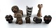 Collection of Upsala-Ekeby pottery figurines, lions, cat, owl, monkeys, bison. A 
total of eight figures.