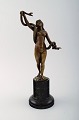 Bronzefigur: Nøgen ung kvinde med slange.
