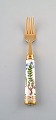 Georg Jensen for Royal Copenhagen. "Flora Danica" dinner fork made of gold 
plated sterling silver. Porcelain handle decorated in colors and gold with 
flowers.