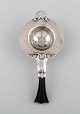 Early and rare art nouveau Georg Jensen tea strainer in silver with ebony 
handle. Dated 1915-30.