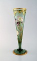 Montjoye, Frankrig. Stor art nouveau vase i mundblæst kunstglas. Dekoreret med 
blomster i emaljearbejde, forgyldt. Vase af høj kvalitet. Dateret 1880-1900.