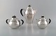 Rare Georg Jensen coffee service in sterling silver with ebony handles. Coffee 
pot, sugar bowl and cream pot. Lid shaped as royal crown. Dated 1915-30.
