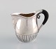 Johan Rohde for Georg Jensen. Kosmos cream jug in sterling silver with ebony 
handle. Design 45D.
