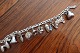 Armbånd, sølv, Bismark-mønster, med 10 charms
- Puddelhund
- Kande
- Sut
- Hat
- Klokke
- Krone
- Agern
- Træsko
- Veteranbil
- Mølle
Barne-armbånd
Fra ca. 1960
Længde 15cm