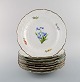 Otte antikke Meissen tallerkener i håndmalet porcelæn med blomstermotiver og 
guldkant. 1800-tallet.
