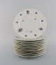 KPM, Berlin. 12 Rubens dinner porcelain plates with floral motifs, gold edge and 
scrolls in relief. 1940