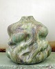 Christina Muff, dansk samtidskeramiker (f. 1971). Smuk skulpturel vase i 
stentøjsler dekoreret med spirende blomsterdetaljer. Glasuren er grøn med noter 
af brunsort og gylden glasur.