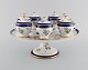 Sevres, France. Seven antique cream cups on compote in hand-painted porcelain 
with flowers and gold decoration. 19th century.
