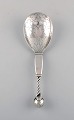 Rare Georg Jensen strawberry spoon in sterling silver designed with openwork 
head and partially twisted handle, knob made with stylized foliage and 
strawberries, dess. 35.
