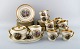 Royal Copenhagen coffee service for 10 people in porcelain with romantic scenes 
and gold decoration. 20th century.
