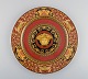 Gianni Versace for Rosenthal. Red Medusa porcelain plate with gold decoration. 
Late 20th century.
