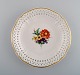 KPM, Berlin. Antique plate / bowl in openwork porcelain with hand-painted 
flowers and gold decoration. 19th century.
