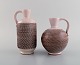 A pair of Töreboda vases with handles in glazed ceramics. Pink pastel glaze and 
fluted body. Swedish design, mid 20th century.

