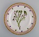 Royal Copenhagen Flora Danica dinner plate in hand-painted porcelain with 
flowers and gold decoration. Dated 1923.
