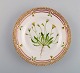 Royal Copenhagen Flora Danica desserttallerken i håndmalet porcelæn med blomster 
og gulddekoration. Modelnummer 20/3551.  
