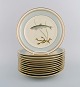 Tolv Royal Copenhagen middagstallerkener i porcelæn med håndmalede fiskemotiver 
og gulddekoration. Midt 1900-tallet. Modelnummer 1158/9581.
