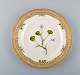 Royal Copenhagen Flora Danica gennembrudt tallerken i håndmalet porcelæn med 
blomster og gulddekoration. Modelnummer 20/3554.  
