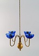 Gunnar Ander for Ystad Metall. Chandelier for four candles in brass and 
mouth-blown art glass shaped like flowers. Scandinavian design, mid 20th 
century.
