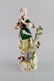 Antique Meissen porcelain figurine. Woman playing flute. Late 19th century.
