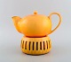 Kähler, Denmark. Teapot with heater for tealights in glazed stoneware. Beautiful 
orange uranium glaze. 1930s / 40s.
