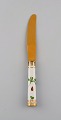 Royal Copenhagen Flora Danica lunch knife of gold plated sterling silver. 
Porcelain handle decorated in colors and gold with flowers.

