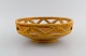 Gunnar Nylund for Rörstrand. Chamotte bowl in openwork glazed ceramics. 
Beautiful mustard yellow glaze. Mid-20th century

