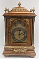 John Bryson, Edingburgh. Large table clock. Watch case in oak. Clockwork is with 
hourly strokes & ½ hourly strokes. There are also  music before the stroke. 
Height 63 cm. Width 36 cm.
