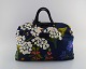 Josef Frank for Svenskt Tenn. Colorful bag with floral motifs. Handles and lock 
in leather and wood. Late 20th century.
