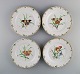 Four antique Royal Copenhagen porcelain dinner plates with hand-painted flowers, 
butterflies and a gold border. Mid-19th century.
