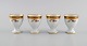 Four Royal Copenhagen Golden Basket egg cups in porcelain with flowers and gold 
decoration. Model number 595/9110. Early 20th century.
