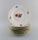 Royal Copenhagen Saxon Flower. Eight dinner plates in hand-painted porcelain 
with flowers and gold decoration. Model number 493/1621. Dated 1953.
