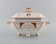 Mintons, England. Antique Holland lidded tureen in hand-painted porcelain. 
Classicist decoration and gold edge. Late 20th century.

