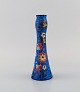 Longwy, Frankrig. Art deco vase i glaseret stentøj med håndmalede blomster på 
blå baggrund. 1920/30