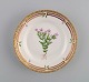 Royal Copenhagen Flora Danica dessert plate in hand-painted porcelain with 
flowers and gold decoration. Model number 20/3551.
