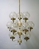 Hans Agne Jakobsson for A / B Markaryd. Large impressive chandelier / ceiling 
lamp. Frame in partially lacquered brass with 11 screens in mouth-blown art 
glass. 1960s.
