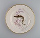 Royal Copenhagen porcelain dinner plate with hand-painted fish motif and golden 
border. Flora / Fauna Danica style. Dated 1963.
