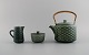 Jens H. Quistgaard (1919-2008) for Nissen Kronjyden. Azur teapot with wicker 
handle, sugar bowl and cream jug in glazed stoneware. 1960s.
