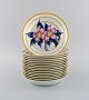 Porcelaine de Paris. "Aurore Tropicale". 15 dybe tallerkener i porcelæn 
dekoreret med blomster og bambus. 1980