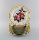 Porcelaine de Paris. "Aurore Tropicale". Twelve porcelain dinner plates 
decorated with pomegranates and bamboo. 1980s.
