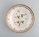 Royal Copenhagen Flora Danica dyb tallerken i håndmalet porcelæn med blomster og 
gulddekoration. 
