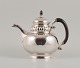 Rare Georg Jensen teapot in three-towered silver.
Handle and lid knob of carved ebony.