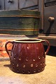 Old 1800s glazed ceramic jar with holes and handle...