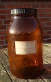 Large and well-maintained 5 liter apothecary bottle in dark brown glass. Labeled "322722" and "Pulvis Dentifricius Camphoratus".