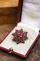 K&Co. præsenterer: Gammel stjerne formet broche med smukke røde granater...